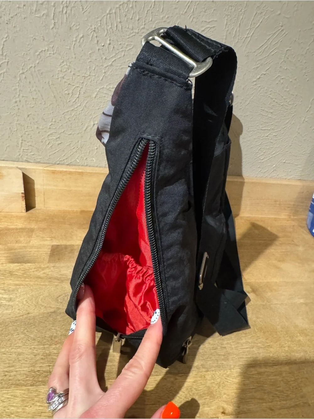 Satchelli Black Crossbody Bag with Floral Accent and Red Lining